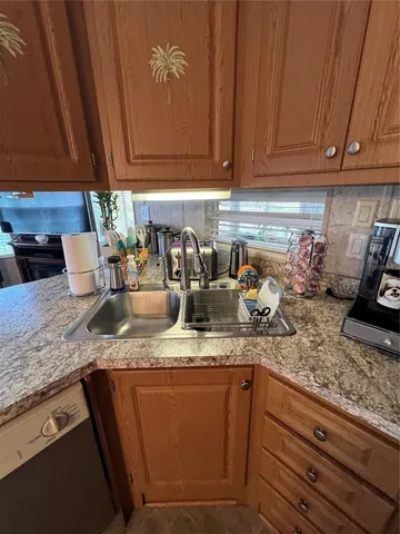 a kitchen with granite countertop a sink a stove and cabinets