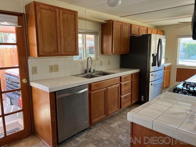 a kitchen with stainless steel appliances a sink cabinets and a refrigerator