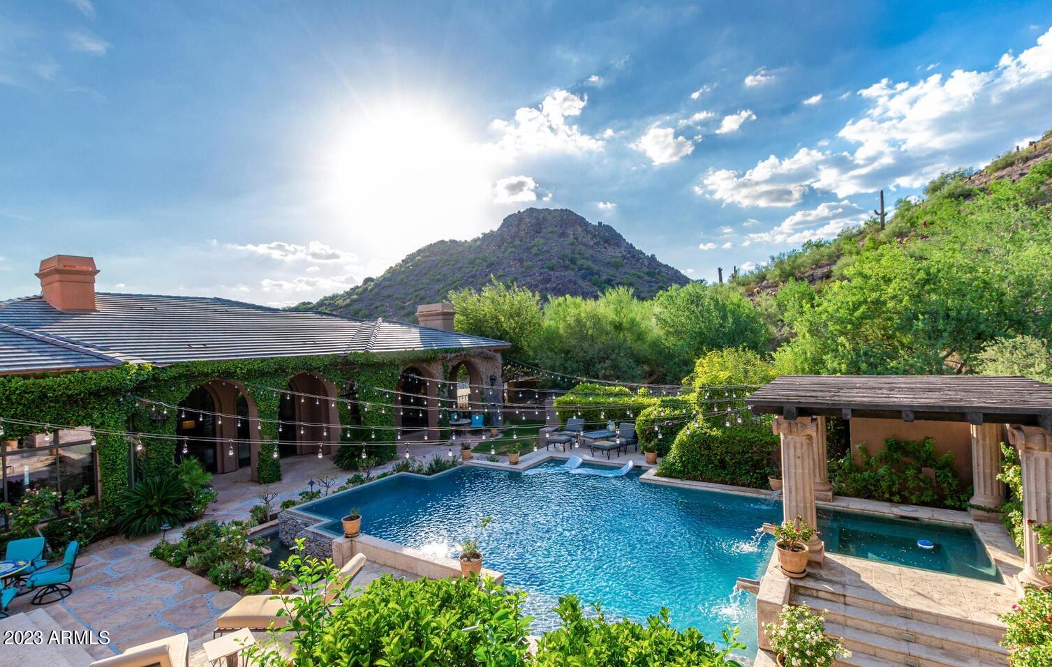 16469 North 113th Way Scottsdale, AZ 85255 - Photo 2 of 47 a view of a patio with couches table and chairs under an umbrella with a fire pit