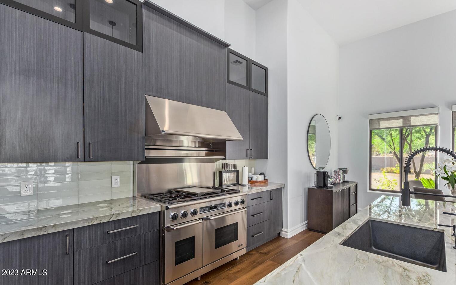 16469 North 113th Way Scottsdale, AZ 85255 - Photo 7 of 47 a kitchen with stainless steel appliances granite countertop a stove a sink and a microwave