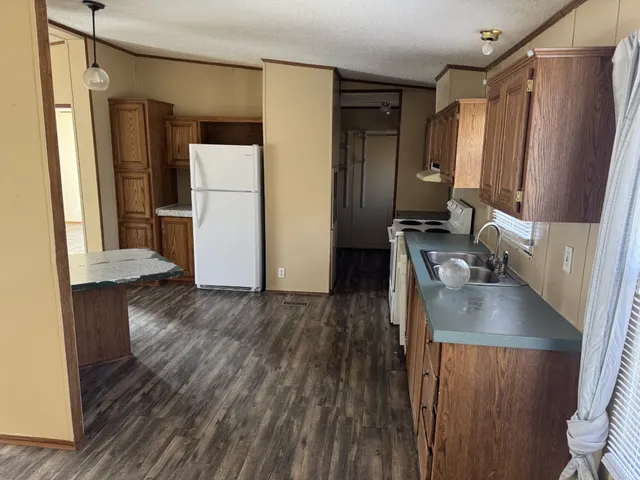 a kitchen with stainless steel appliances a refrigerator sink and wooden floor