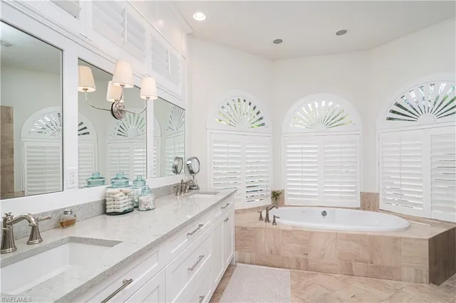 a bath room with double vanity sinks and a bathtub