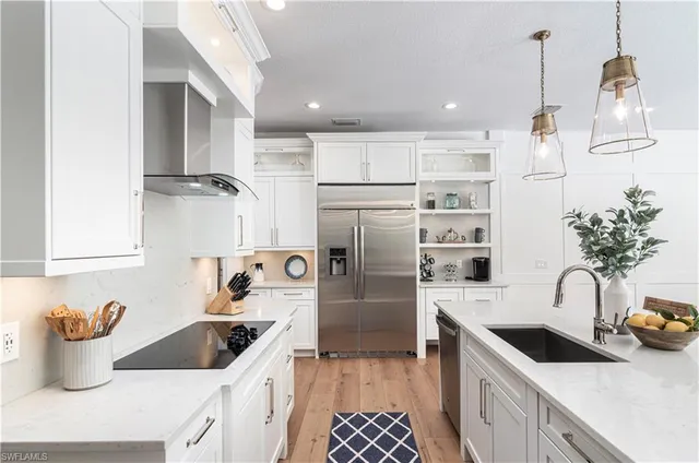 a kitchen with stainless steel appliances granite countertop a sink a stove and a refrigerator