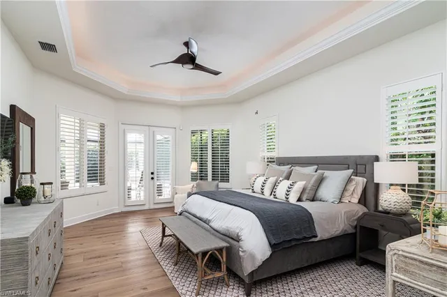 a spacious bedroom with a bed a couch and a flat tv screen