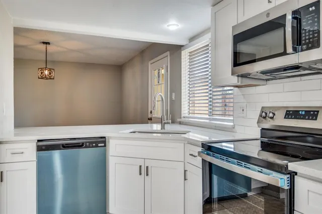 a kitchen with stainless steel appliances granite countertop a sink stove and microwave