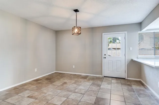 a view of a room with a chandelier fan and windows