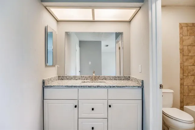 a bathroom with a granite countertop sink and a mirror