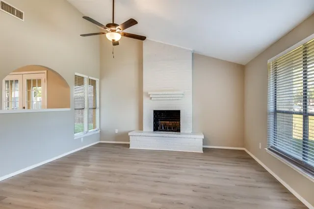 a view of an empty room with window and fireplace