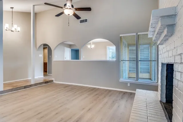 an empty room with windows and fireplace