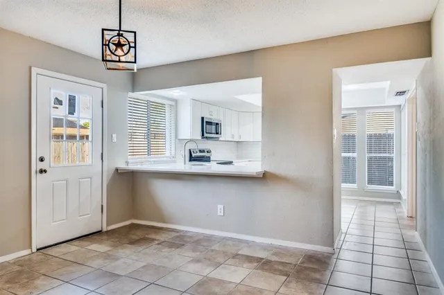a view of kitchen with granite countertop cabinets and window