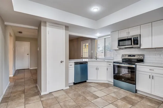 a kitchen with stainless steel appliances granite countertop a refrigerator and a stove top oven