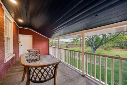 a view of a porch with furniture and wooden floor