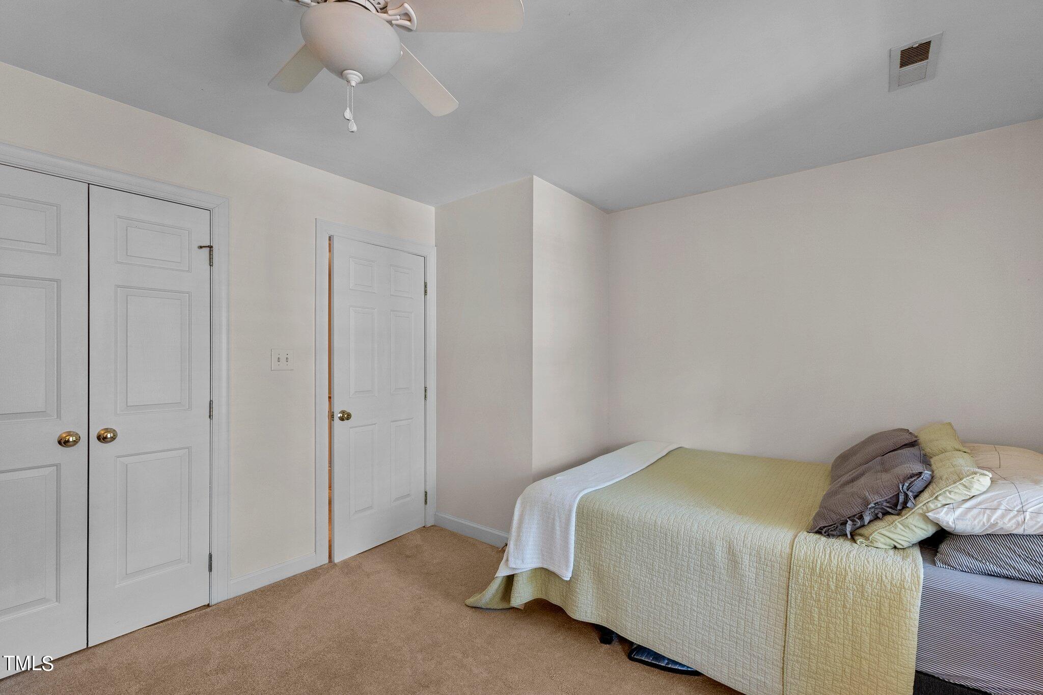 2110 Reaves Drive Raleigh, NC 27608 - Photo 18 of 36 a bedroom with a bed and a chandelier fan