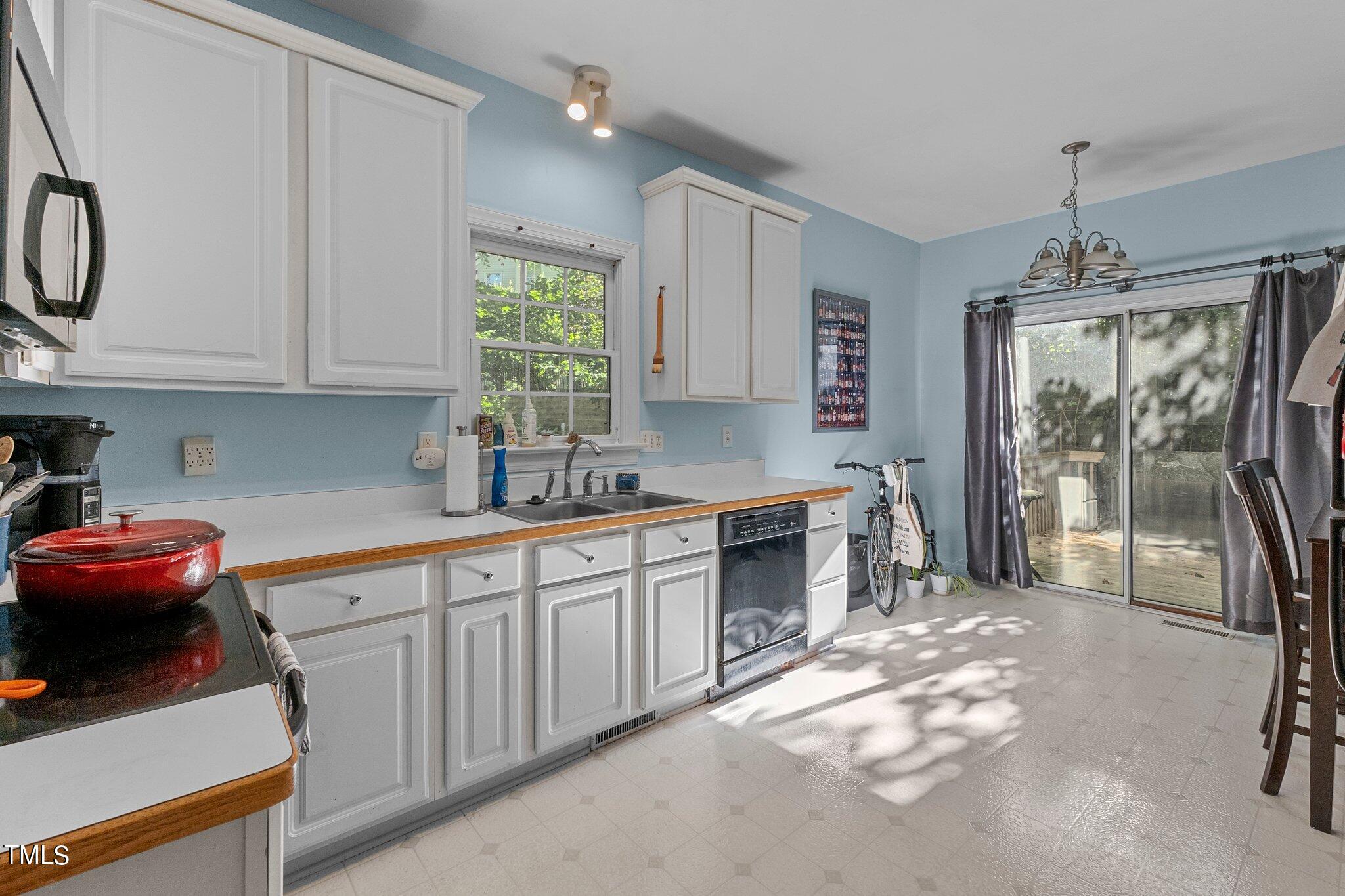 2110 Reaves Drive Raleigh, NC 27608 - Photo 6 of 36 a kitchen that has a sink cabinets appliances and a window