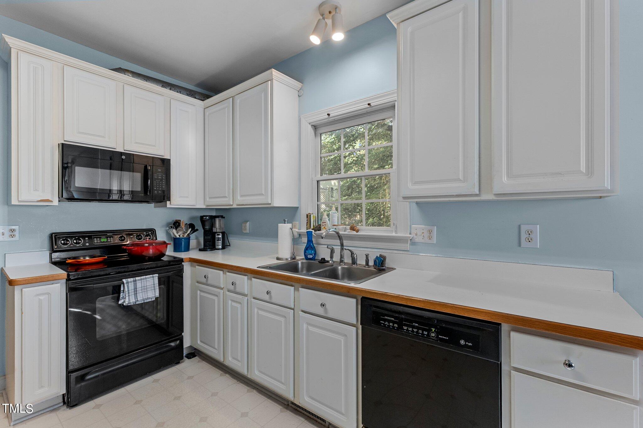 2110 Reaves Drive Raleigh, NC 27608 - Photo 7 of 36 a kitchen with stainless steel appliances granite countertop a sink dishwasher a stove and a microwave oven with cabinets