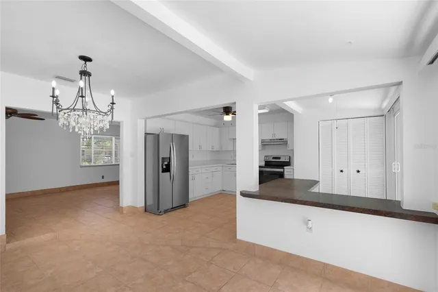 a view of a hallway with wooden floor and chandelier