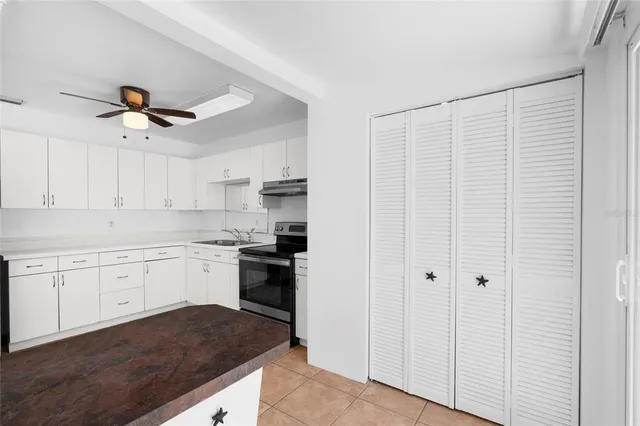 a kitchen with granite countertop white cabinets and white appliances