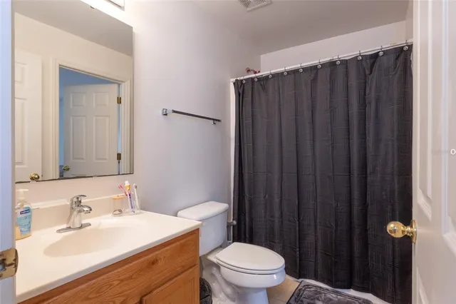 a bathroom with a sink vanity mirror and toilet