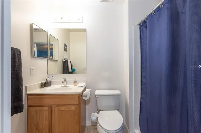 a bathroom with a sink vanity mirror and toilet