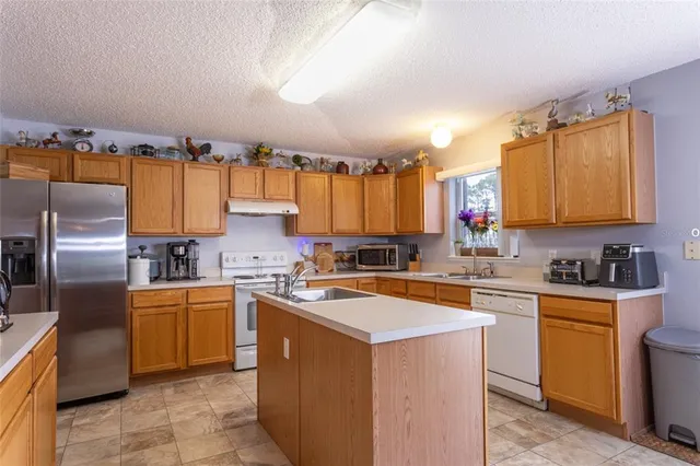 a kitchen with a sink a counter top space cabinets and stainless steel appliances