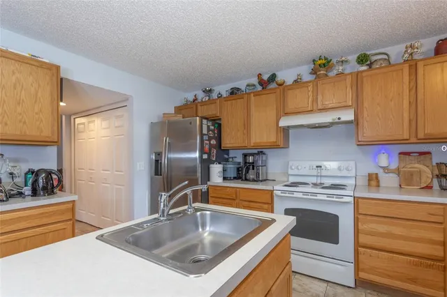 a kitchen with stainless steel appliances a sink a stove and a refrigerator