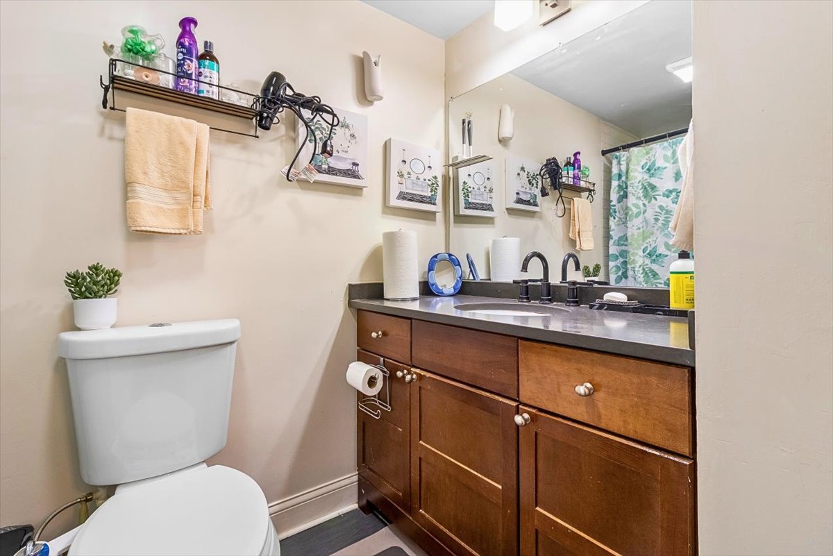 6881 Hickory Street Hanover Park, IL 60133 - Photo 10 of 23 a bathroom with a toilet sink and mirror