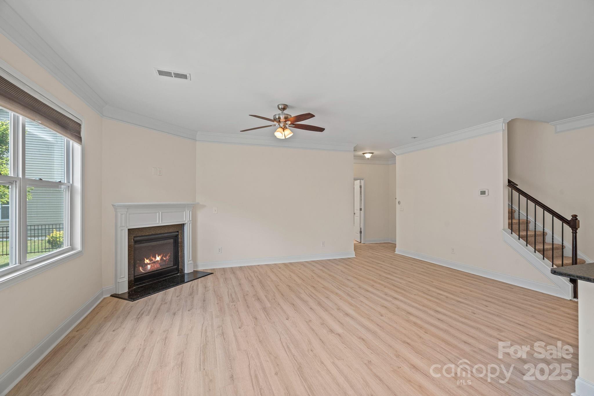 2079 Lakebridge Drive Fort Mill, SC 29715 - Photo 11 of 33 a view of an empty room with wooden floor fireplace and a window