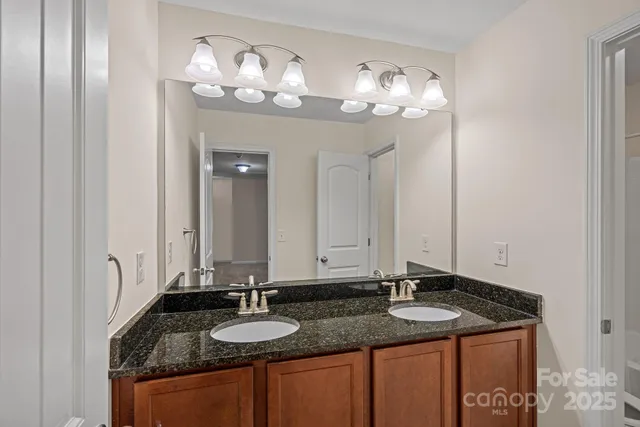 a bathroom with a granite countertop sink a large mirror and a shower