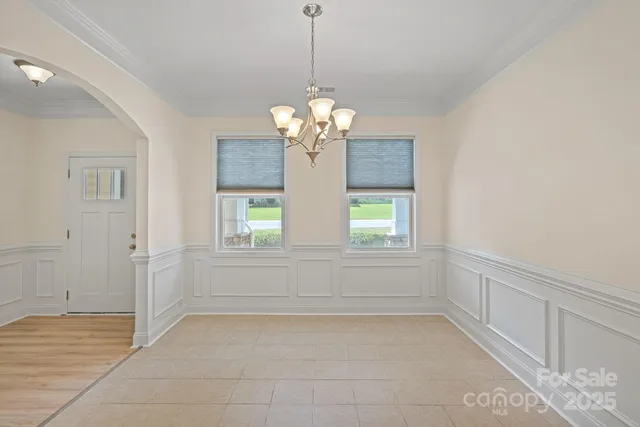 a view of kitchen with chandelier and window