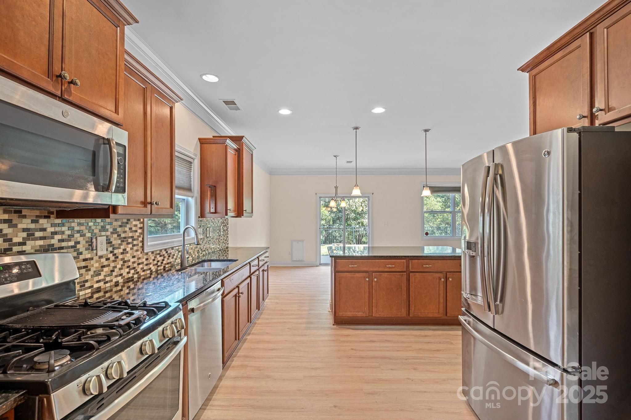 2079 Lakebridge Drive Fort Mill, SC 29715 - Photo 6 of 33 a kitchen with stainless steel appliances granite countertop a refrigerator a stove and a wooden cabinets