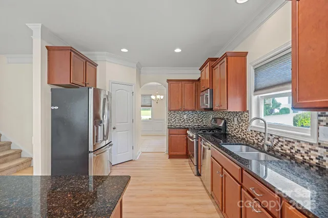 a kitchen with stainless steel appliances granite countertop a refrigerator and a sink