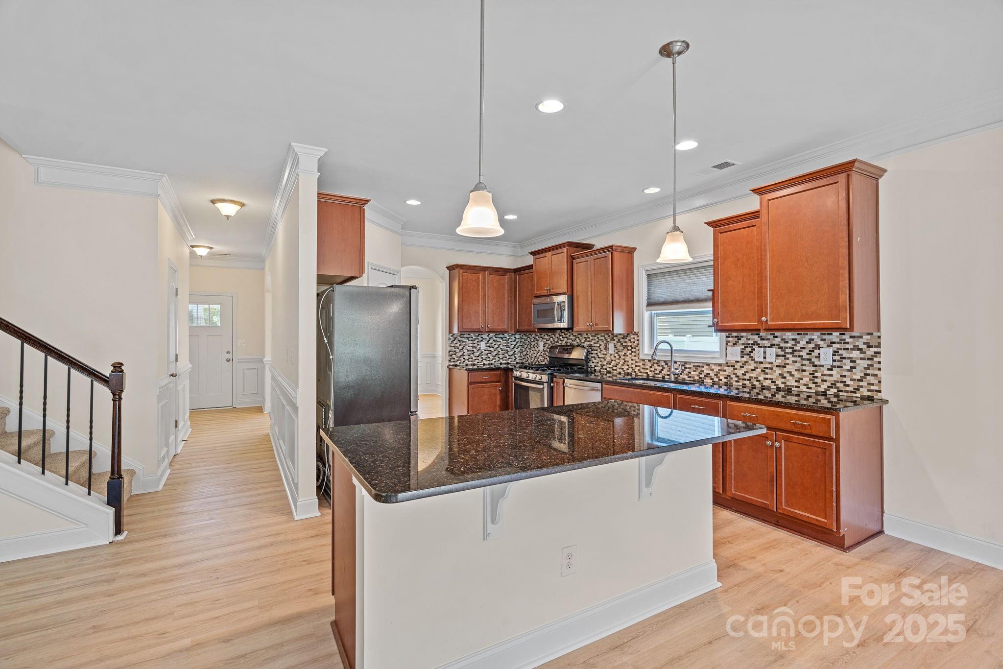 2079 Lakebridge Drive Fort Mill, SC 29715 - Photo 9 of 33 a kitchen with stainless steel appliances granite countertop a sink a refrigerator and wooden floor