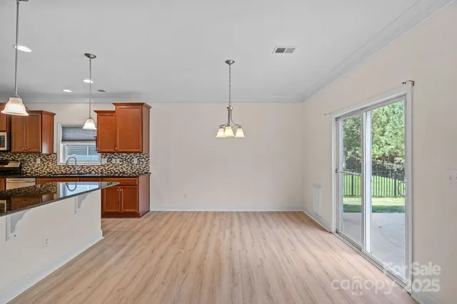 a kitchen with stainless steel appliances granite countertop a stove a sink and a wooden floors
