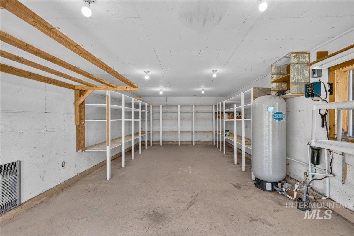 1071 Reynolds Road Princeton, ID 83857 - Photo 32 of 43 Utility room featuring extensive built-in shelving, concrete flooring, exposed wood ceiling beams, and integrated ceiling lighting