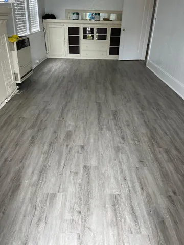 an empty room with wooden floor and a fireplace