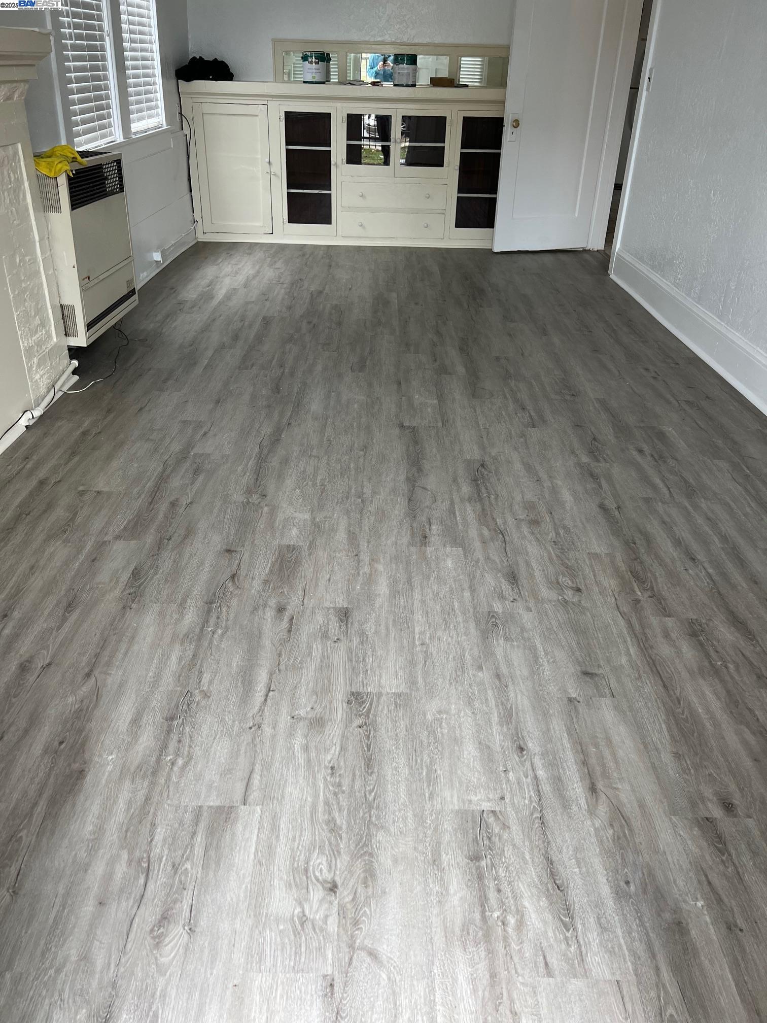 583 8th Street Richmond, CA 94801 - Photo 2 of 2 an empty room with wooden floor and a fireplace