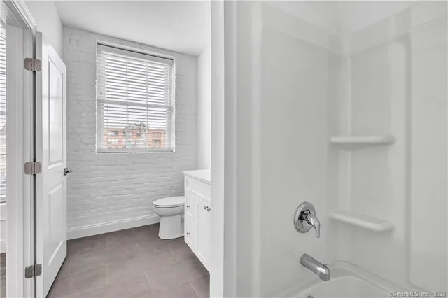 a bathroom with a toilet a sink and a window