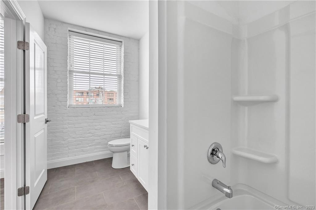 a bathroom with a toilet a sink and a window
