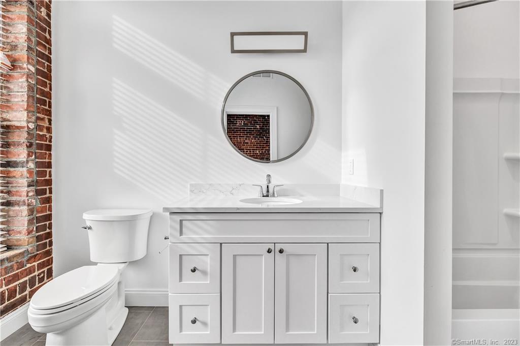 475 Howe Avenue, Unit 5 Shelton, CT 06484 - Photo 16 of 31 a bathroom with a toilet a sink and a mirror