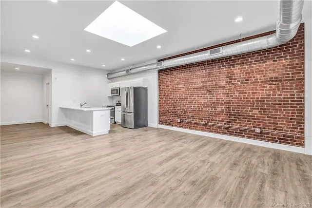 a view of an empty room with a wooden floor and a window