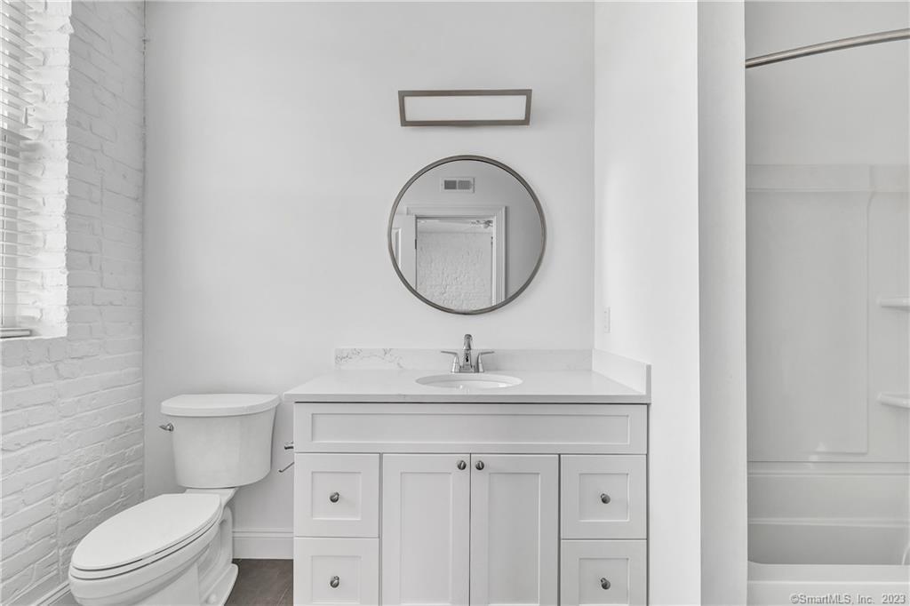 475 Howe Avenue, Unit 5 Shelton, CT 06484 - Photo 2 of 31 a bathroom with a granite countertop toilet sink and mirror