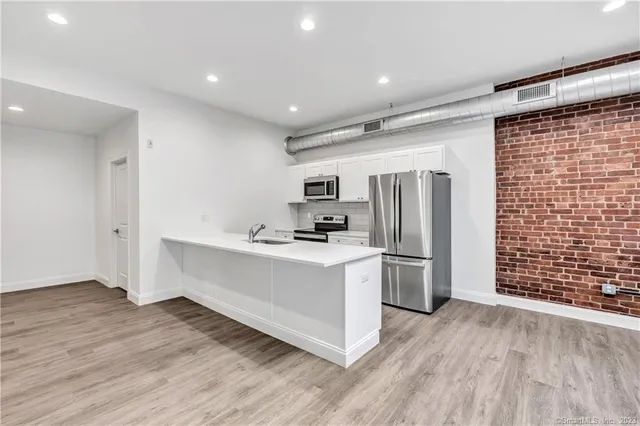 a kitchen with stainless steel appliances a refrigerator and a stove top oven