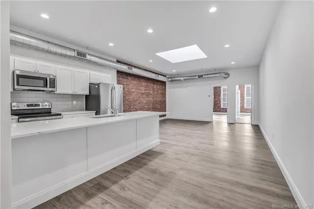 a view of kitchen with stainless steel appliances a refrigerator and a stove top oven