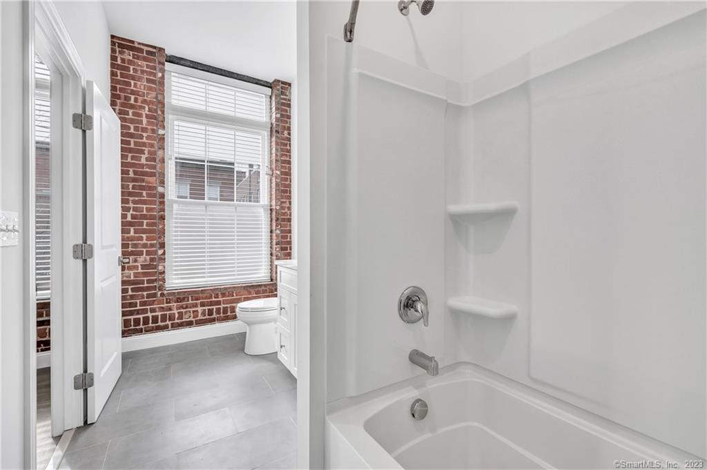 475 Howe Avenue, Unit 5 Shelton, CT 06484 - Photo 3 of 31 a bathroom with a bathtub and a shower