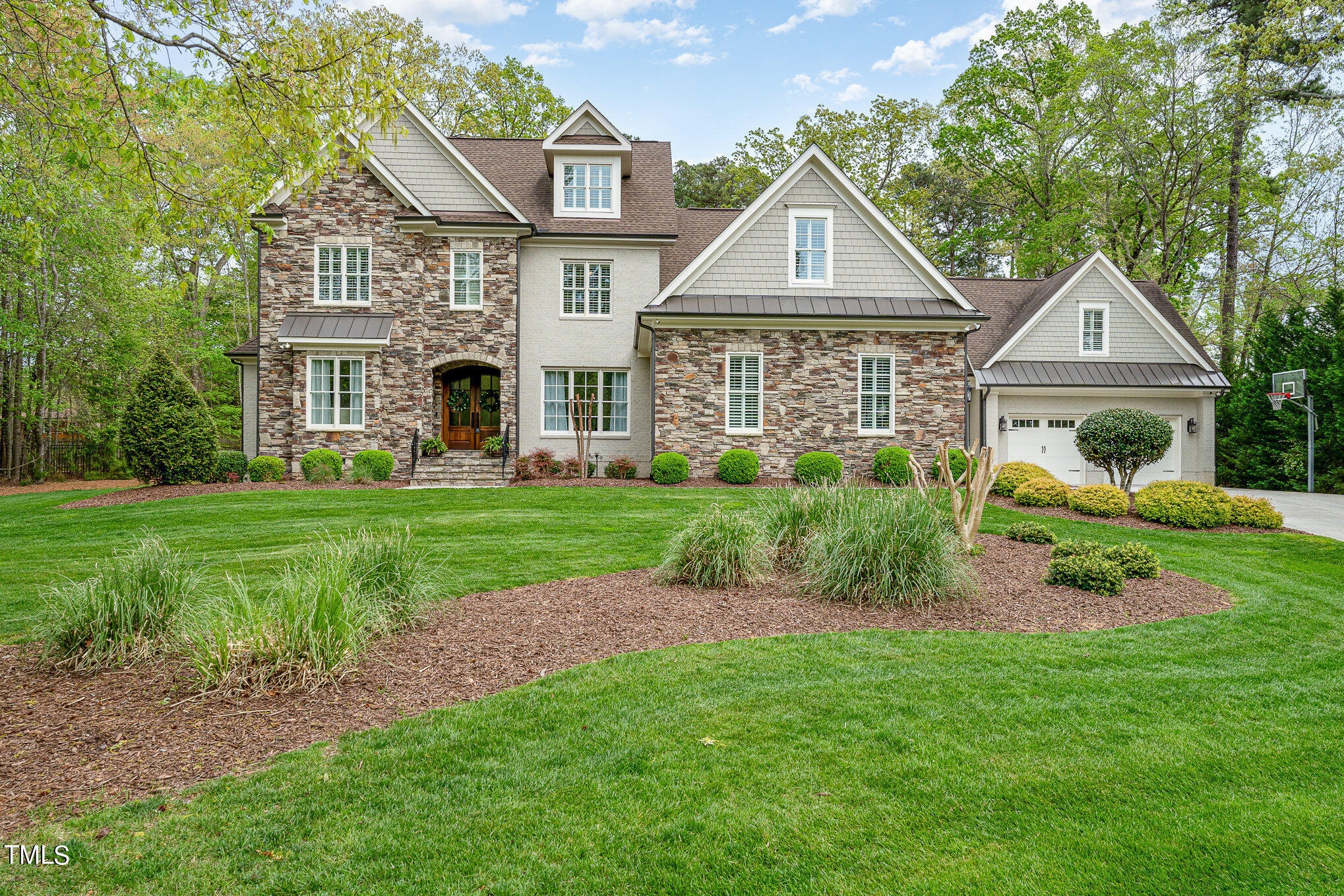 a front view of a house with a yard and trees