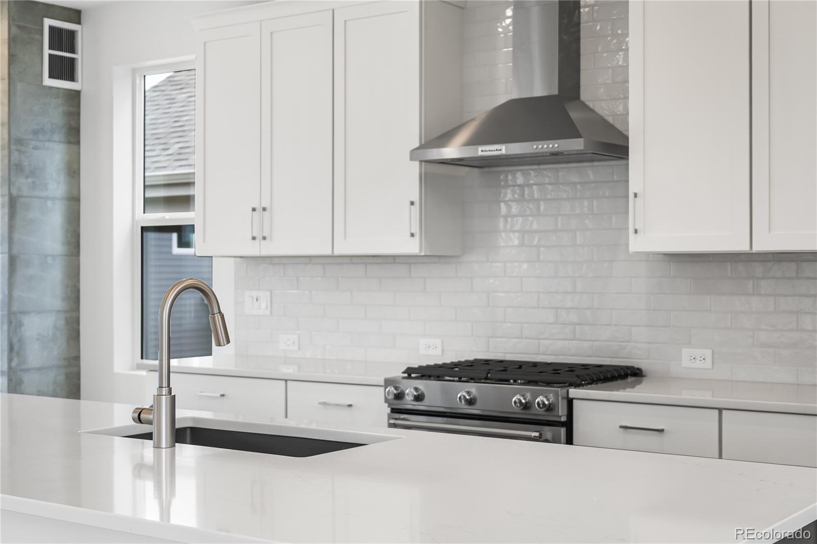 11972 Octave Avenue Lone Tree, CO 80134 - Photo 11 of 31 a kitchen with granite countertop a sink and a stove