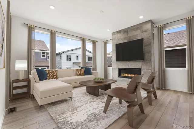 a living room with furniture a flat screen tv and a fireplace