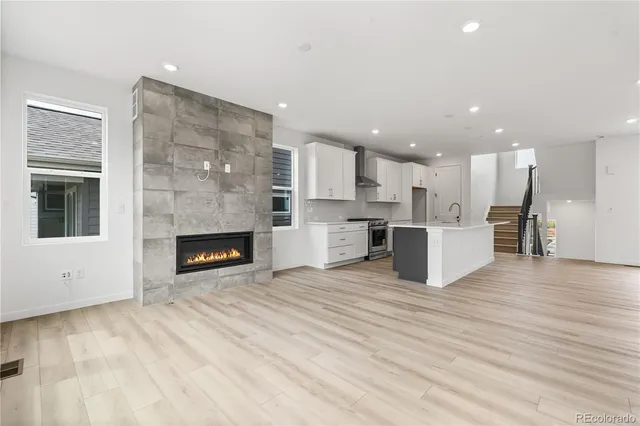 a view of kitchen with kitchen island wooden floor center island and stainless steel appliances