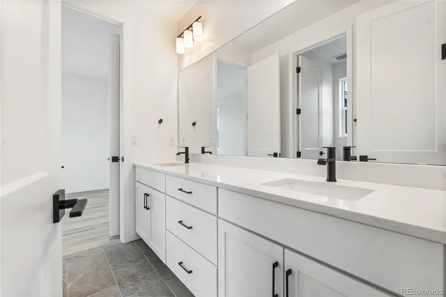 a bathroom with double vanity sink and a mirror