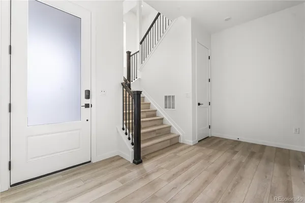 a view of entryway with wooden floor and staircase